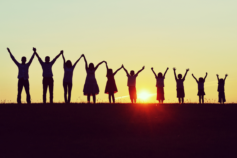 People silhouettes on sunset meadow having fun