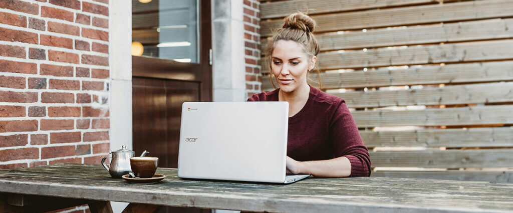 Kvinna-arbetar-vid- laptop-utomhus-med-kaffe-på-bordet