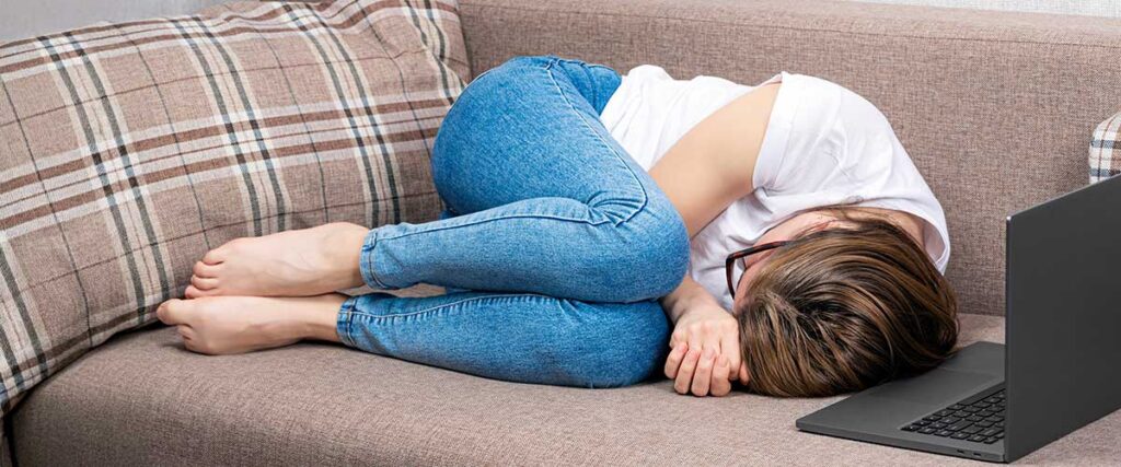 Kvinna-ligger-i-soffan-ihopkrupen