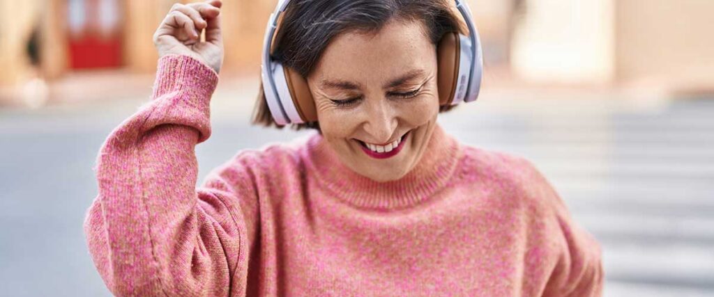 Kvinna-i-hörlurar-och-med-en-rosa-tröja-dansar