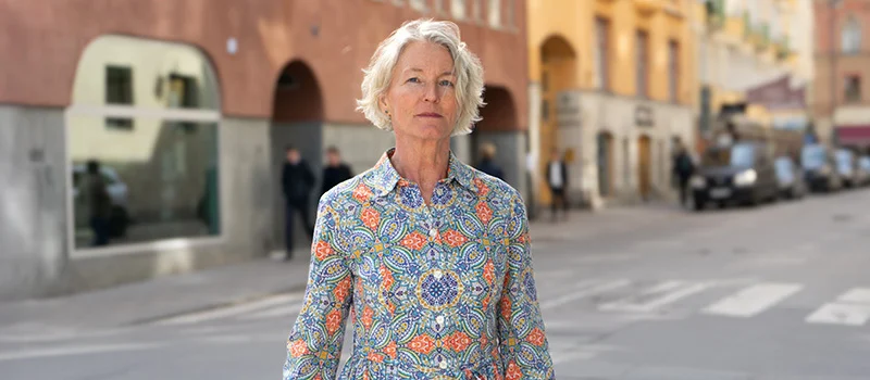 En-kvinna-står-på-gatan-med-armarna-neråt