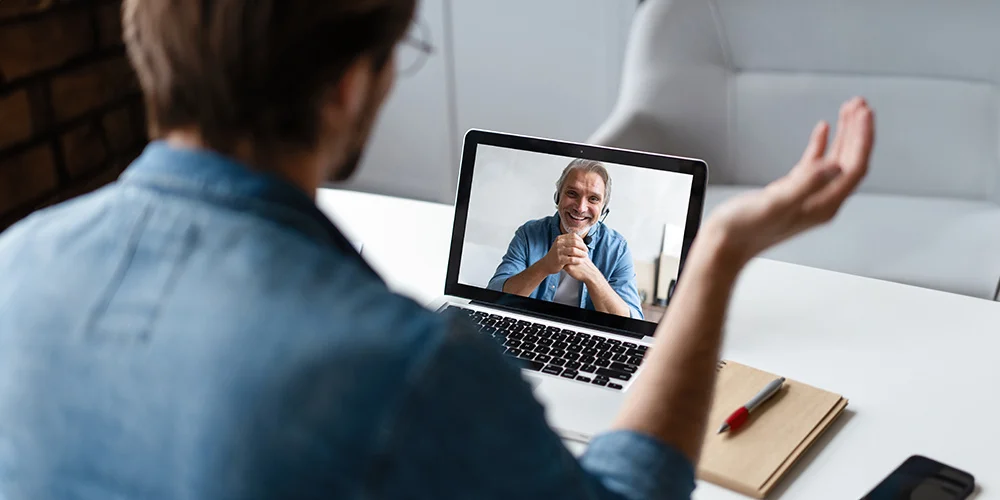 En-man-har-möte-på-sin-laptop-med-en-annan-man